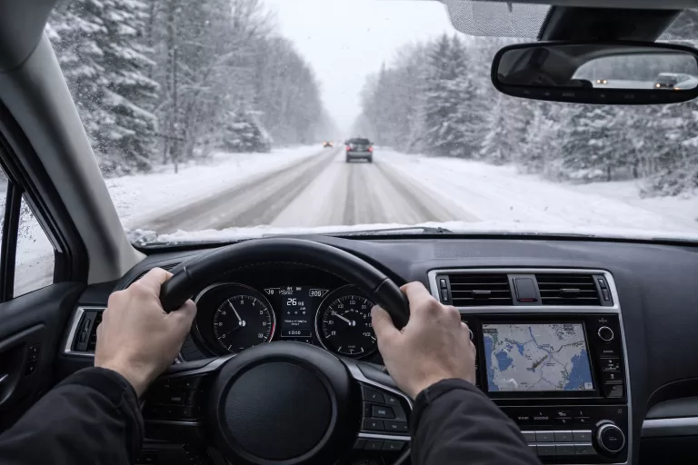 Driver traveling cautiously on a snow-covered highway during winter in the United States